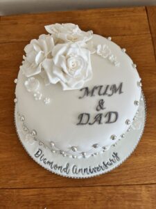 White diamond anniversary cake with white roses and flowers