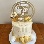 White chocolate drip cake with 16 cake topper meringues and chocolates