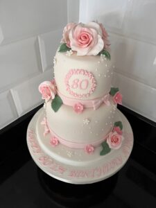 2 tier white 80th birthday cake with modelled roses