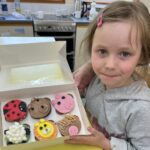 child holding cupcakes