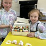 2 children showing their decorated cupcakes